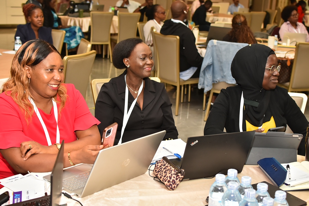 Participants completing practical AI exercises on laptops in Uganda